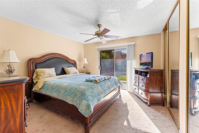 bedroom featuring a textured ceiling, ceiling fan, access to exterior, and light colored carpet