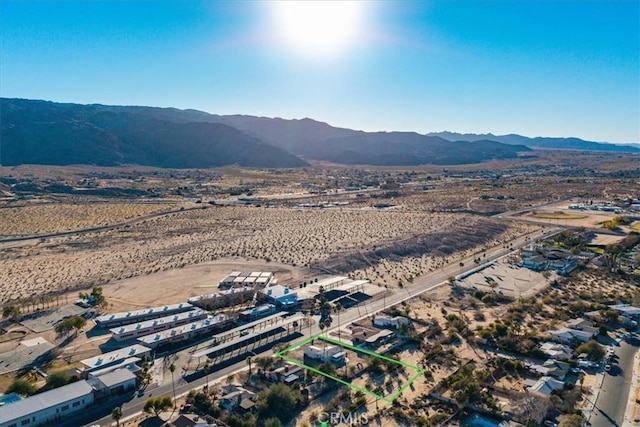 drone / aerial view featuring a mountain view and a desert view