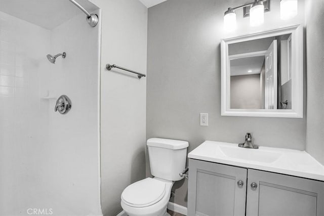 bathroom featuring a shower, toilet, and vanity