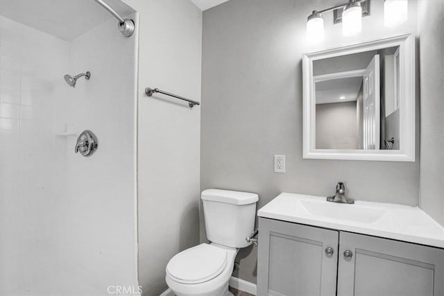 bathroom with a shower, vanity, and toilet