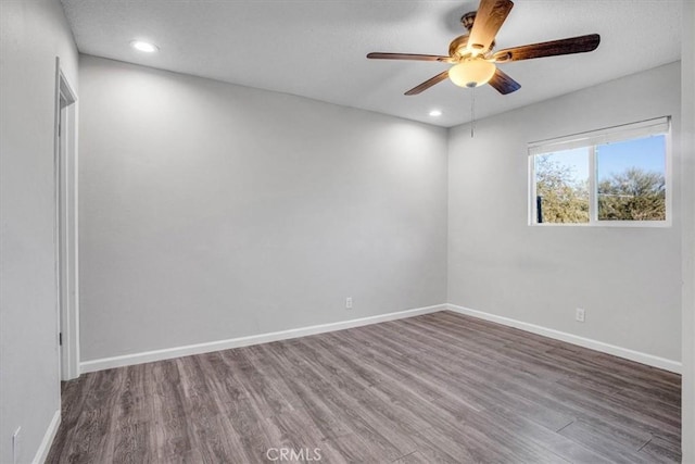 spare room featuring recessed lighting, wood finished floors, and baseboards