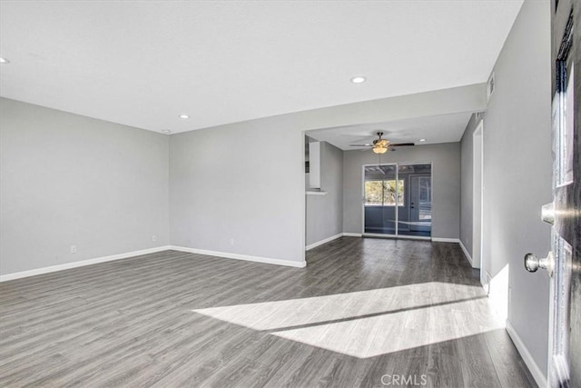 unfurnished living room featuring wood finished floors, a ceiling fan, and baseboards