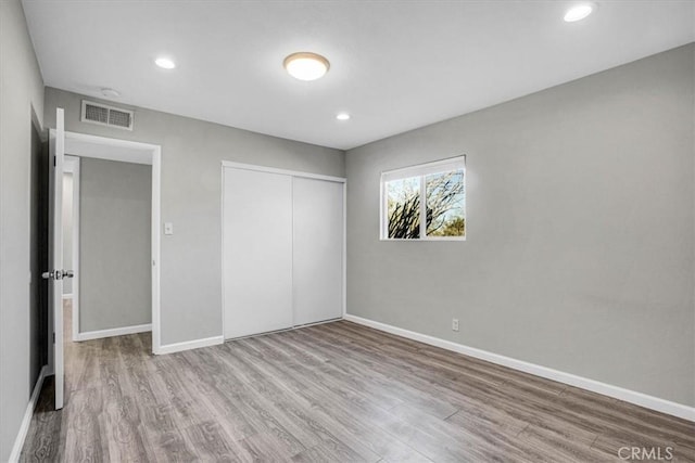 unfurnished bedroom with a closet and light hardwood / wood-style floors