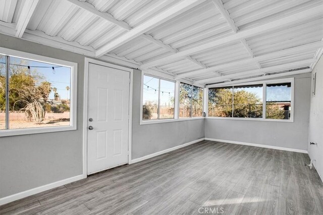 unfurnished sunroom with beamed ceiling