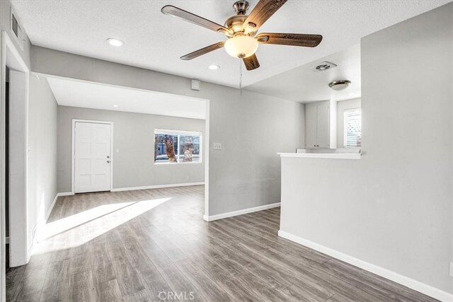 empty room featuring ceiling fan, a textured ceiling, and hardwood / wood-style flooring