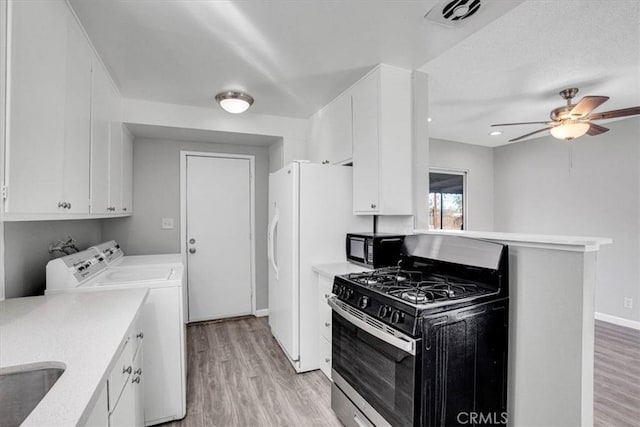 kitchen featuring range with gas cooktop, ceiling fan, white cabinetry, light hardwood / wood-style flooring, and washer and clothes dryer