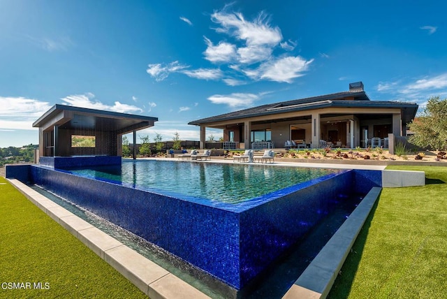 view of pool with a lawn and a patio