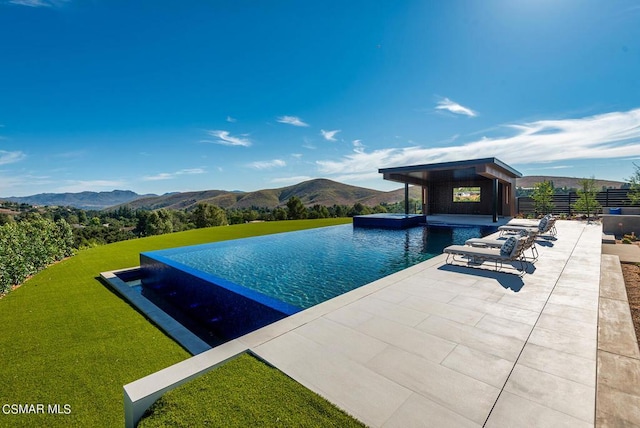 view of pool with a patio area and a mountain view