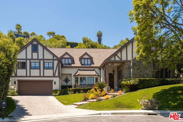 english style home with a front lawn and a garage