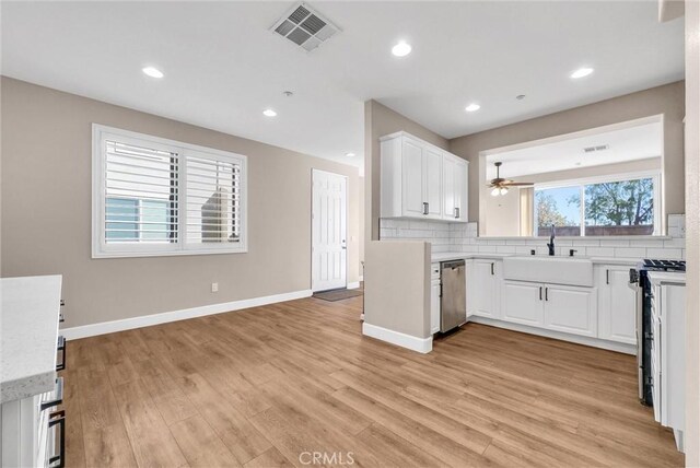 kitchen with decorative backsplash, sink, white cabinets, and stainless steel appliances