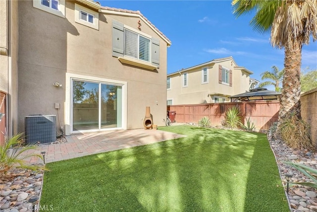 rear view of house featuring central air condition unit, a patio area, and a yard