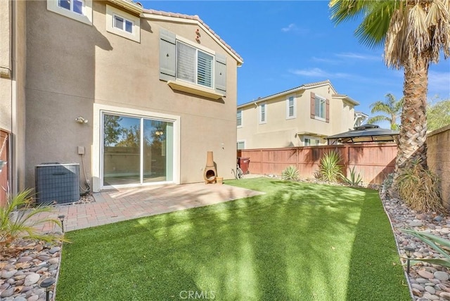 rear view of house featuring a yard, a patio, and central AC unit