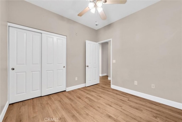 unfurnished bedroom featuring ceiling fan, light wood-type flooring, and a closet