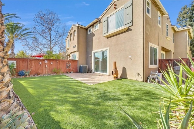 back of property with central air condition unit, a patio, and a yard