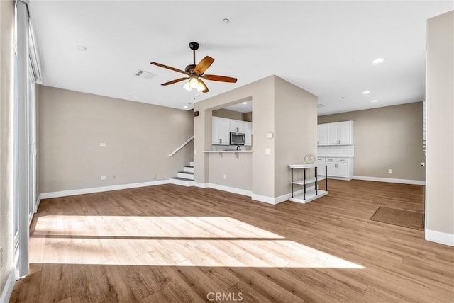 unfurnished living room with ceiling fan and light wood-type flooring