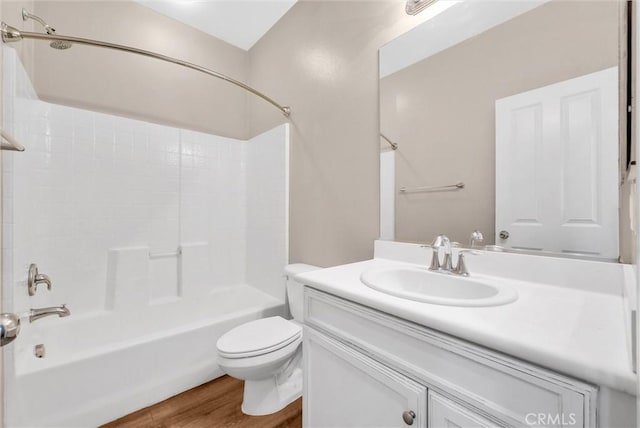 full bathroom featuring hardwood / wood-style floors, bathtub / shower combination, vanity, and toilet