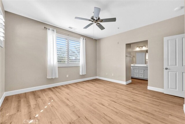 unfurnished bedroom featuring ceiling fan, connected bathroom, and light hardwood / wood-style flooring