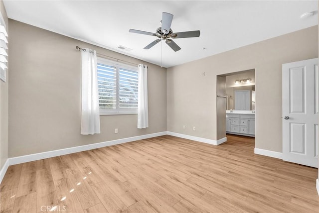 unfurnished bedroom featuring ceiling fan, light wood-type flooring, and connected bathroom