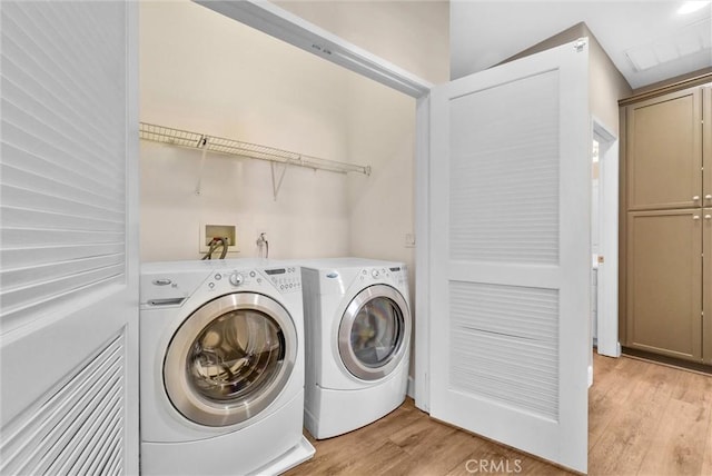 laundry room featuring light hardwood / wood-style floors and separate washer and dryer