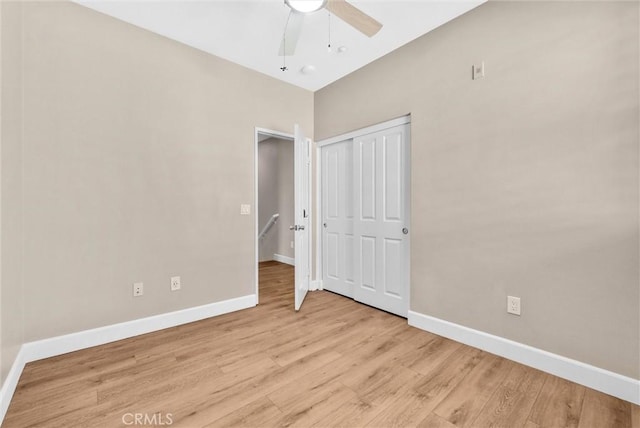 unfurnished bedroom featuring ceiling fan, light hardwood / wood-style flooring, and a closet