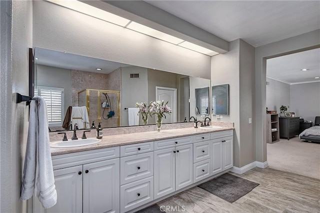 bathroom featuring a shower with door and vanity