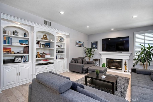 living room with light wood-type flooring and built in features