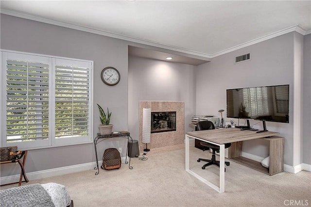 office area with light colored carpet, a tiled fireplace, and a wealth of natural light