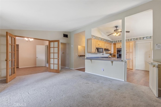 unfurnished living room with light carpet, lofted ceiling, ceiling fan with notable chandelier, and french doors