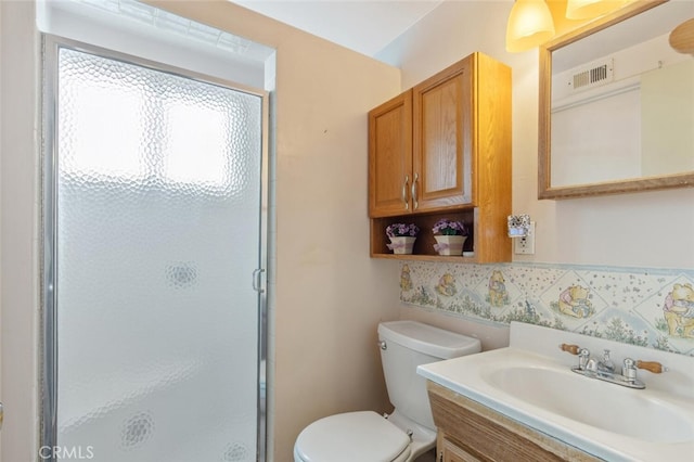 bathroom featuring a shower with shower door, vanity, and toilet