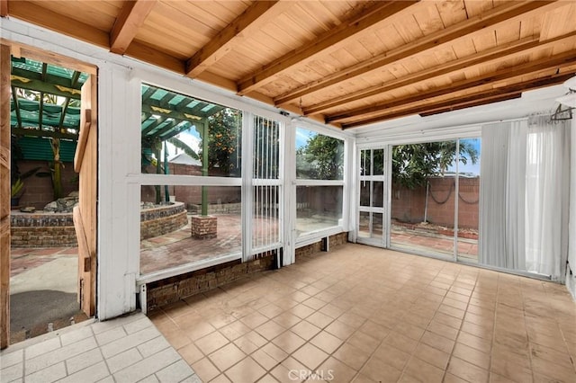 unfurnished sunroom with vaulted ceiling with beams, wood ceiling, and plenty of natural light