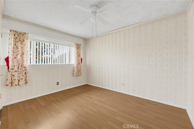 unfurnished room featuring ceiling fan, hardwood / wood-style floors, and a textured ceiling