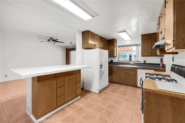 kitchen with light tile patterned floors, ceiling fan, white fridge with ice dispenser, range, and sink