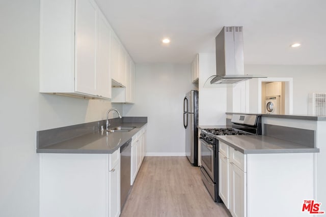 kitchen featuring white cabinets, island exhaust hood, stainless steel appliances, sink, and light hardwood / wood-style flooring