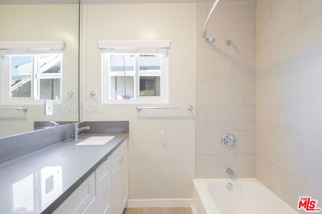 bathroom featuring vanity and tiled shower / bath