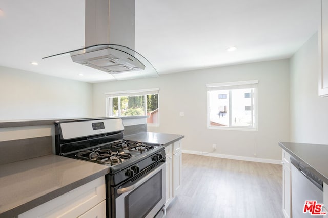 kitchen featuring white cabinets, appliances with stainless steel finishes, island exhaust hood, and light hardwood / wood-style flooring