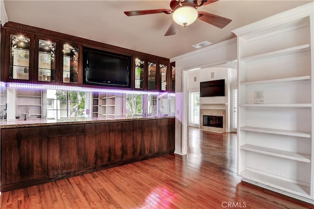 bar with hardwood / wood-style flooring, ceiling fan, and dark brown cabinetry