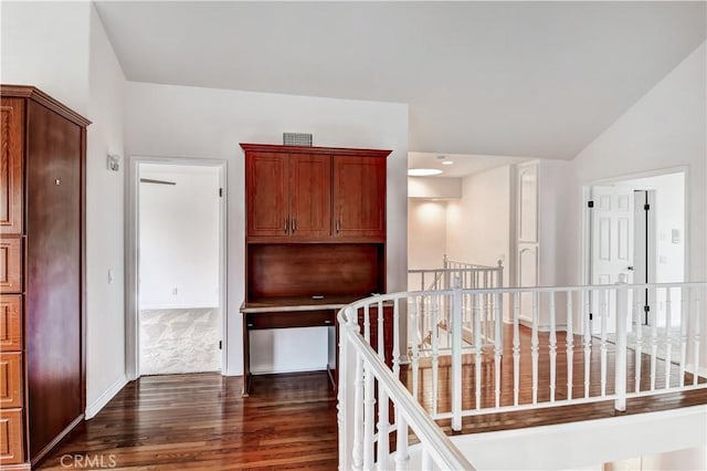 corridor with lofted ceiling and dark hardwood / wood-style flooring