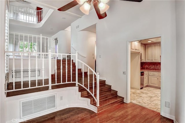 stairs featuring ceiling fan and hardwood / wood-style floors