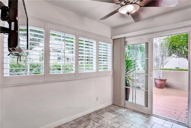 unfurnished sunroom with ceiling fan and a healthy amount of sunlight