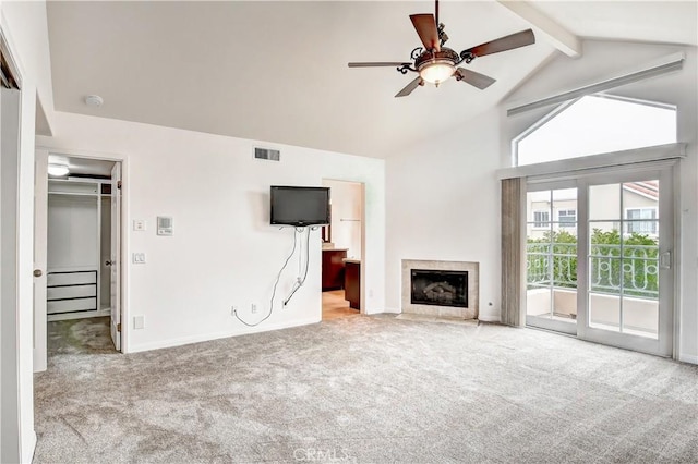 unfurnished living room with lofted ceiling with beams, carpet, a fireplace, and ceiling fan