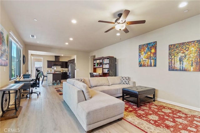 living room featuring light wood-type flooring and ceiling fan