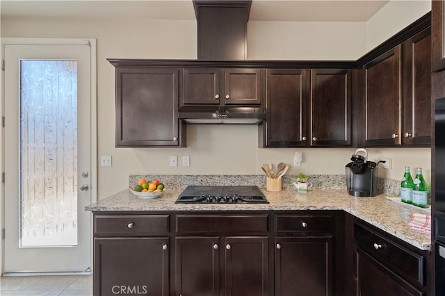 kitchen with light stone counters, black gas cooktop, and dark brown cabinetry