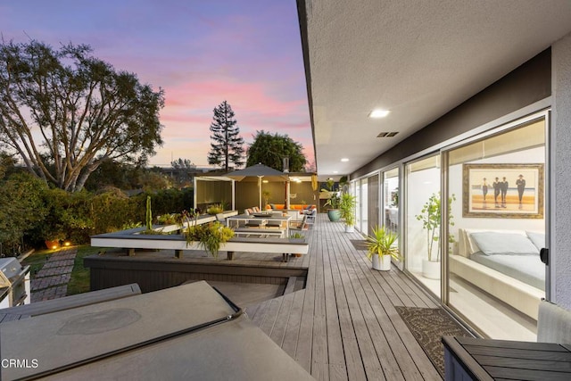 deck at dusk featuring an outdoor living space