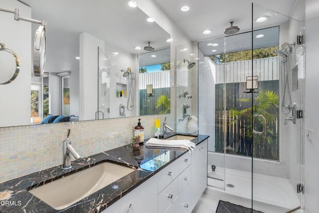 bathroom featuring a shower with shower door, vanity, and tasteful backsplash