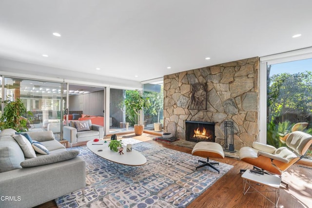 living room with floor to ceiling windows, hardwood / wood-style floors, and a fireplace