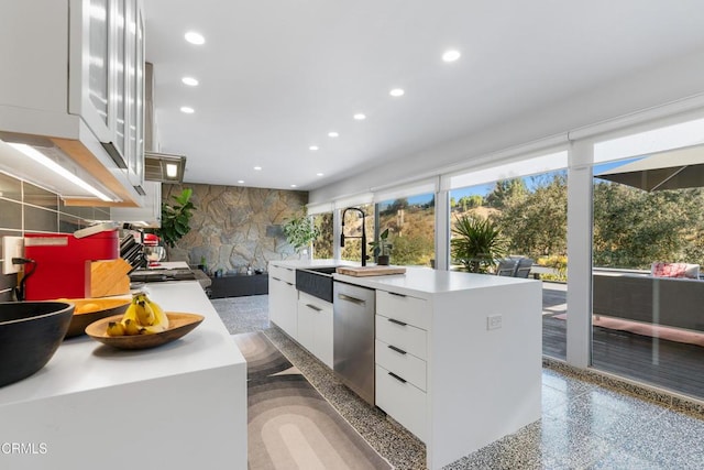 kitchen with sink, dishwasher, white cabinets, and a center island