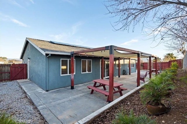 rear view of house with a patio area and solar panels