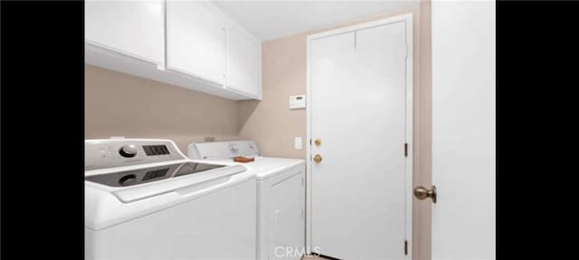 washroom with washer and clothes dryer and cabinets