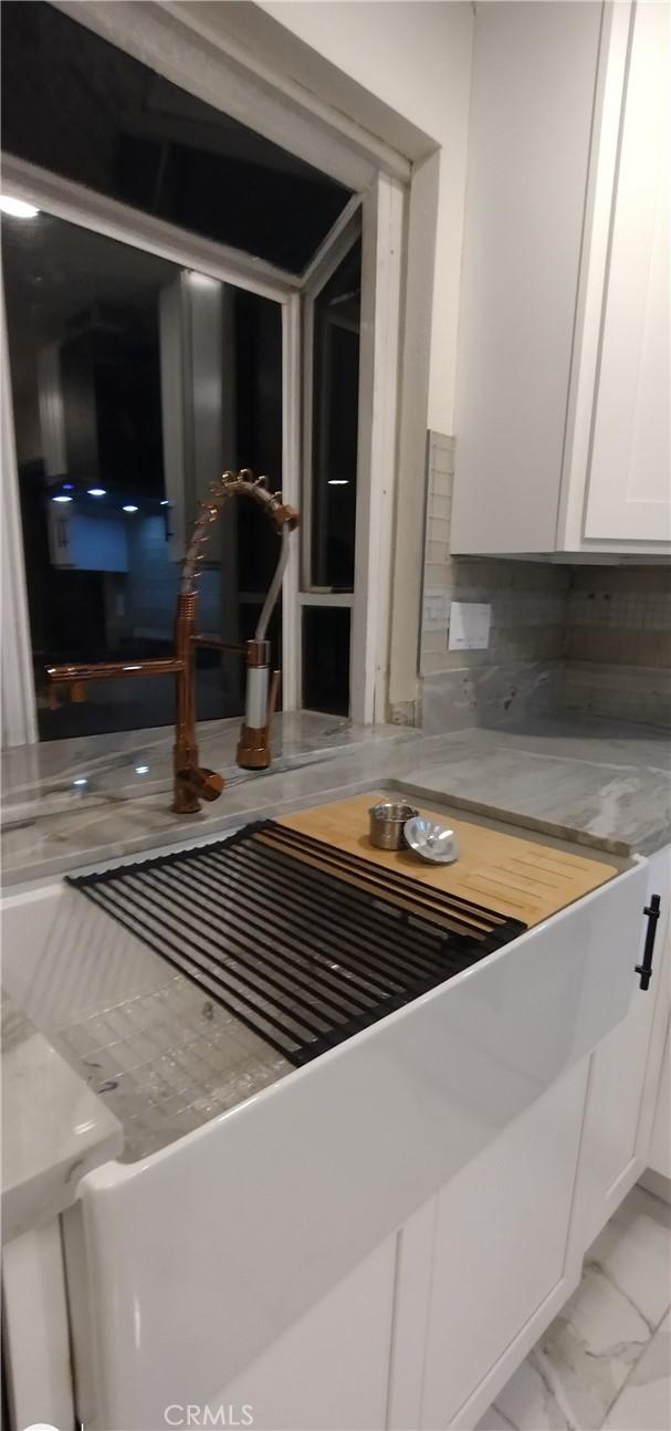 interior details featuring white cabinetry and tasteful backsplash