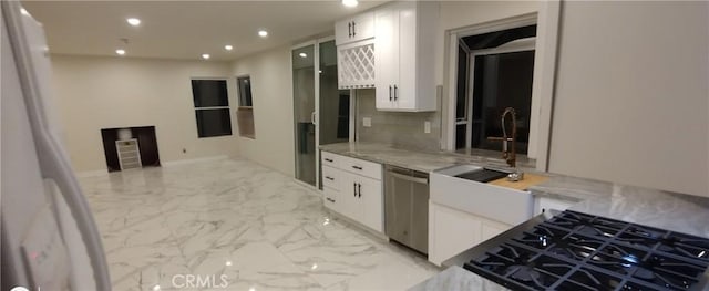 kitchen with white cabinetry, stainless steel dishwasher, backsplash, and light stone counters